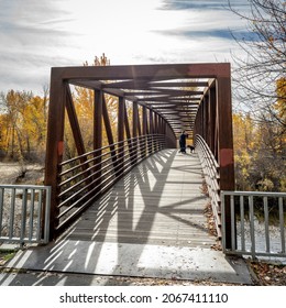 Dog Walker On Bridge Over Boise River In Fall