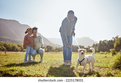 Dog, Walking And Family Relax Together In Nature Park Enviroment. Black Family, Pet And Father Walk Puppy In Garden With Mother And Child For Freedom, Happiness And Animal Care On Countryside Field