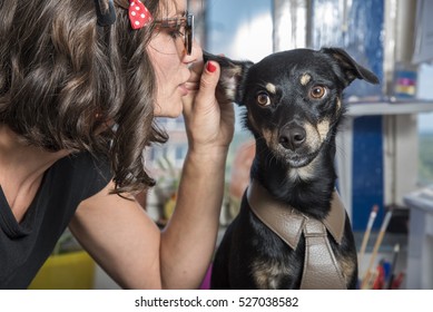 Dog whisperer, puppy gossip; young retro woman whispering things into little cute dog's ear