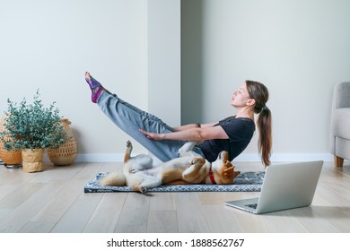 Doga Or Doga Yoga Is The Practice Of Yoga As Exercise With Dogs. Young Woman In Yoga Position Balancing With Her Dog. Home Online Training With A Pet