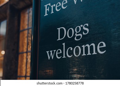 Dogs welcome sign outside traditional English pub in Stow on the Wold, Cotswolds, UK, in the evening, selective focus.
