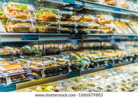DOHA, QATAR - FEB 28, 2020: Pre-packaged sandwiches, salads and drinks displayed in a commercial refrigerator