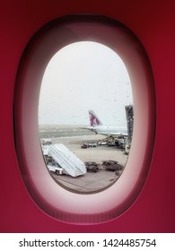 Doha, Qatar - February, 2019 : Views Out Of Airplane Windows Of Qatar Airplane To See Other Plane Tale Parking At Hamad International Airport