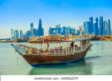Doha, Qatar - February 23, 2019: people tourists on dhow and seafront of Doha West Bay skyline with Qatar International Exhibition Center, Doha Tower, Salam Tower, World Trade Center, Bank Tower.