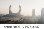 Doha, Qatar [February 24, 2025]: A foggy morning in Doha with skyscrapers partially hidden in mist, creating a mysterious and serene cityscape.