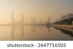 Doha, Qatar [February 24, 2025]: A foggy morning in Doha with skyscrapers partially hidden in mist, creating a mysterious and serene cityscape.