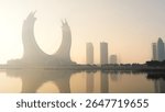 Doha, Qatar [February 24, 2025]: A foggy morning in Doha with skyscrapers partially hidden in mist, creating a mysterious and serene cityscape.