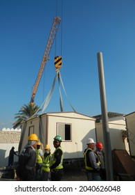 DOHA, QATAR - Jan 29, 2014: A Closeup Shot Of Construction Crane Lifting A Cabin In A Major Construction Project In Doha, Qatar