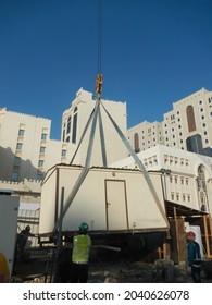 DOHA, QATAR - Jan 29, 2014: A Construction Crane Lifting A Cabin, Engineer Controlling The Major Construction Project In Qatar