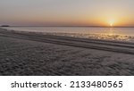 Doha, Qatar- March 11,2022 : Sunset in Sealine with beautiful sand pattern emerged due to low tide.