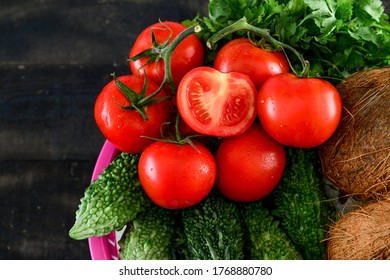 Doha, Qatar - May 02, 2020:  mix Vegetable .tomato, Quora ,karela, in basket on black wooden table 
