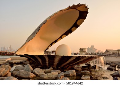 DOHA, QATAR - NOVEMBER 2, 2016. Pearl monument in Doha, with people, cars, boats and buildings in the background, at dawn.