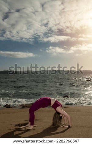 doing bridge handstand on the beach wearing sportswear