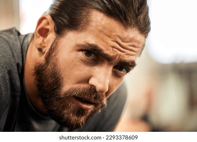Doing challenging things will make you the strongest. Portrait of a sporty young man catching his breath while exercising in a gym.