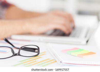 Doing creative work. Cropped image of man working on laptop while sitting at his working place