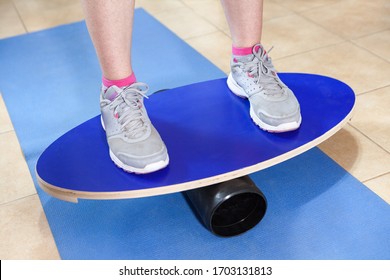 Doing Exercises On Balance Board, Person Balancing And Holding Stability.