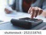 Doing finance, budgeting and tax calculation. Close up woman hand using calculator to calculate home finance, accounting with laptop computer on table, budget management, monthly expenses