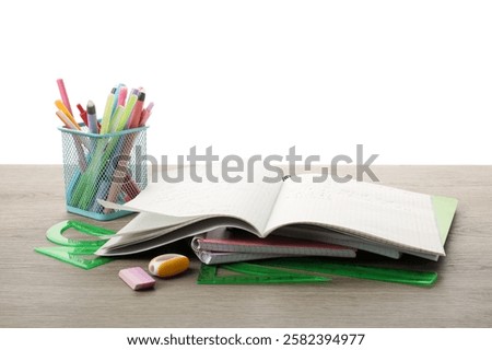 Doing homework. Copybook with math assignment and different stationery on wooden table against white background