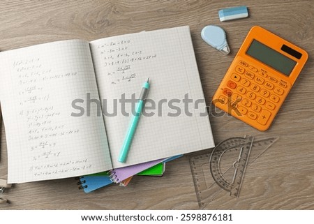Doing homework. Notebook with math assignment and stationery on wooden desk, flat lay