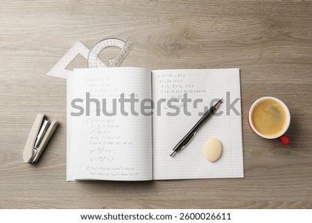 Doing homework. Notebook with math assignment and stationery on wooden desk, flat lay