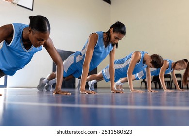 Doing push-ups on court, basketball team training in gym. Fitness, exercise, teamwork, athletes, sports - Powered by Shutterstock