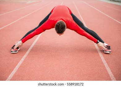 Doing some stretching before a run. Young athlete getting ready for a run.