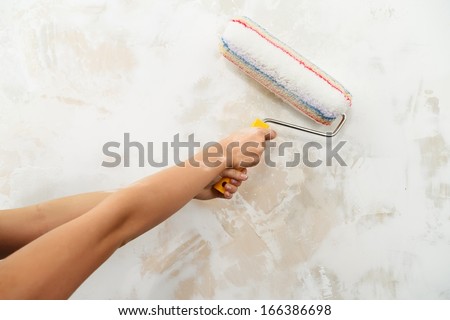 Doing wallpainting with a roller 