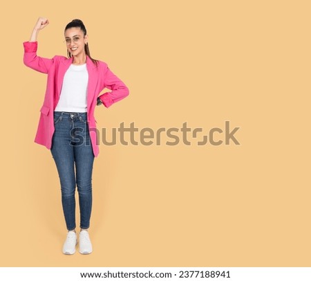 Doing winner gesture, full length body view young business woman doing winner gesture. Office worker employee entrepreneur wear formal pink jeans. Celebrating raise one arm up clenched fist. 
