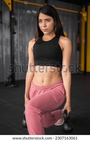 doing workout for legs with dumbbells, healthy and physically active lifestyle, young latin woman with long hair wears sports top and leg warmer