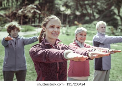 Doing yoga. Three wonderful woman and one handsome serious man doing yoga during their leisure on fresh air - Shutterstock ID 1317238424