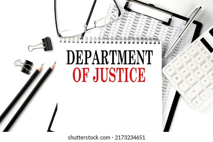 DOJ - Department of Justice word on a notepad with clipboard , chart and calculator, business concept