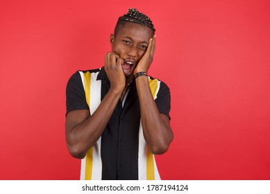 Doleful Desperate Crying African American Man With Braids Wearing Casual Shirt Over Isolated Red Background Being In Depression After Quarrel With Wife Or Girlfriend, Looks Stressfully, Frowns Face,