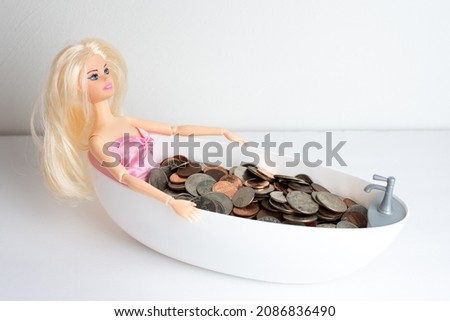 Doll in a bath of coins. American coins. Cents.