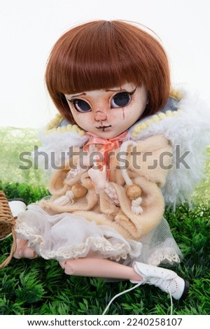 doll expressive face big eyes scary plastic face portrait in green background