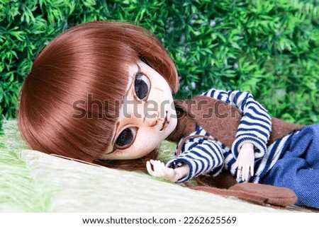 doll face kid child toy lying beautiful redhead puppet in green background
