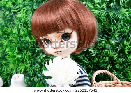 doll face portrait toy red hair girl in green background