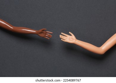Doll hands on a gray background. Help, friendship concept