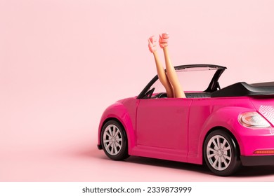Doll legs sticking out of a pink car. Fashion, summer trip, vacation concept. 
