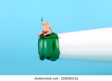 A Doll Sitting At The Mouth Of A Wine Bottle And Drinking