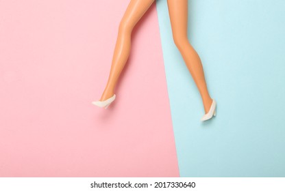 Doll woman legs in high heel shoes on a blue pink pastel background. Minimalism fashion concept