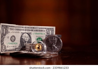 Dollar American Silver Eagle and gold British Britannia on a table top with blurred background