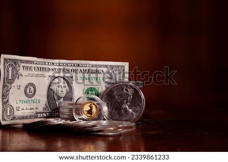 Dollar American Silver Eagle and gold British Britannia on a table top with blurred background