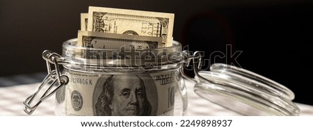 Dollar banknote saving money in glass jar. Consumption and economy Collecting money. Banner Tips. Business, finance, saving, banking and people concept. Extra money, passive income