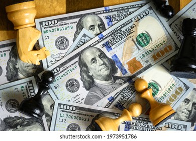 Dollar bills and chess game, top view of US paper currency and chess pieces on chessboard. Concept of money strategy, unfair competition, gamble, stock market, economy crisis and financial risk.