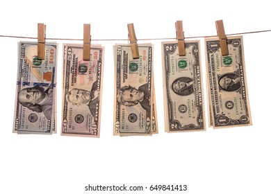 Dollar bills on clothespins on white background. Concept of laundering of money