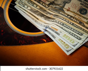 Dollar on Guitar on dark background