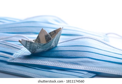 Dollar tosses on the waves. Financial problems concept, banknote origami-ship with surgical masks. - Shutterstock ID 1811174560