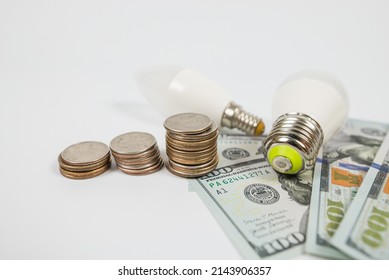 Dollars Cents And Two Energy Saving Light Bulbs. Energy Saving Concept.