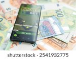 dollars and euros, smartphone with sports bet application