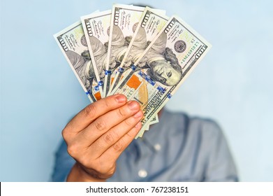 dollars in the hands. Businessman in blue shirt holding a 500 dollars. a fan of money